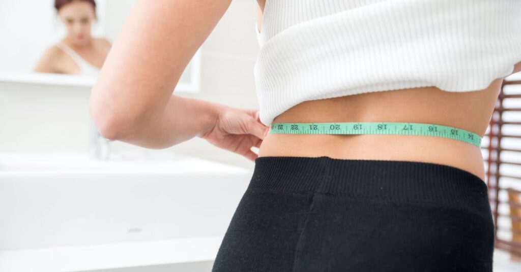 woman using tape to check for weight loss